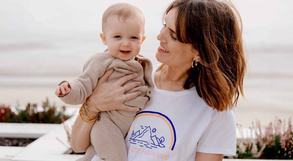 Meilleurs conseils parents pour vivre parentalité : maman souriante et son bébé près de la mer