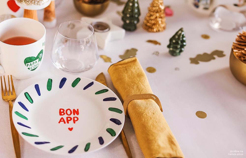 Repas Noël enceinte :
assiette festive avec l’inscription “Bon App” et serviette dorée, idéale pour un repas de Noël personnalisé pour femme enceinte. Comment décorer sa table de Noël en incluant des plats adaptés à la grossesse ?