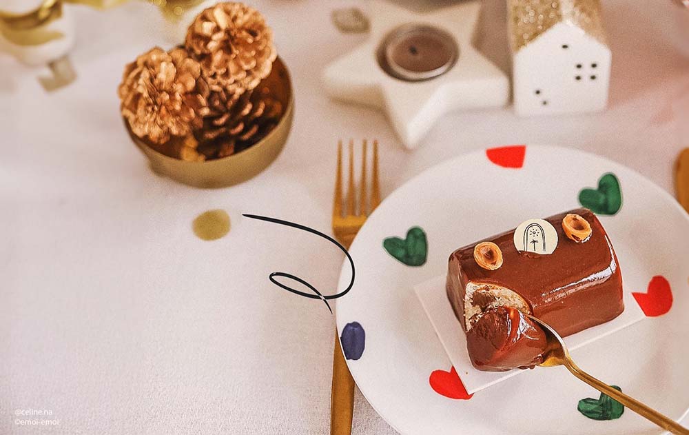 Manger une bûche de Noël enceinte :
Mini bûche de Noël au chocolat pour femme enceinte, posée sur une assiette festive décorée de cœurs colorés. Peut-on manger des pâtisseries ou des desserts à Noël pendant la grossesse ? Conseils sur les bûches et dessert sans risque.